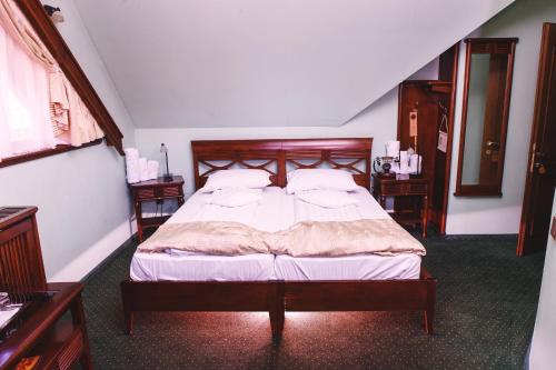 a bedroom with a bed with a wooden headboard at Pension Brasovu Vechi in Braşov