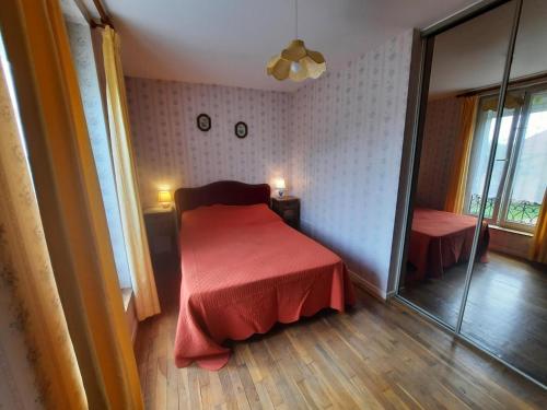 una camera con un letto con copriletto rosso di Le fournil a Chuffilly-Roche
