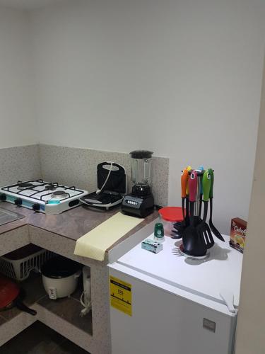 a kitchen with a counter with a stove and a refrigerator at Posada J&J Forbes - 2 in San Andrés