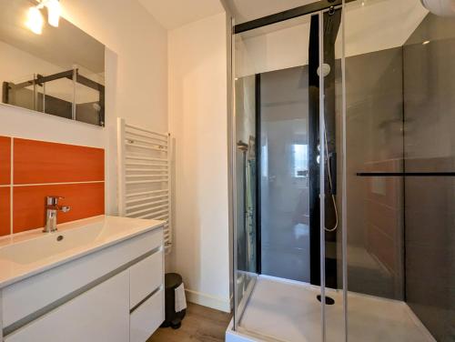 La salle de bains est pourvue d'une douche et d'un lavabo. dans l'établissement Concept Appar't Hôtel - 201, à Saint-Brieuc