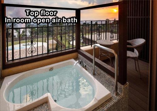 a hot tub in a room with a balcony at La Vista Kirishima Hills in Kirishima