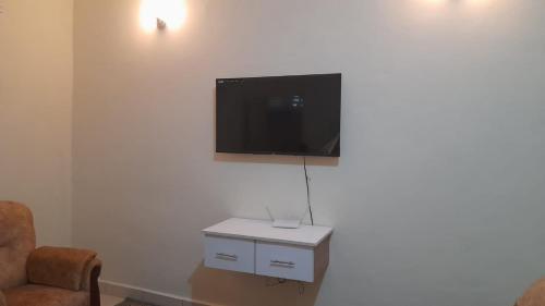 a living room with a tv on a white wall at Crown Apartments in Malindi