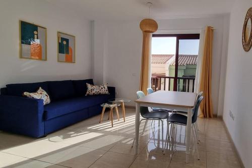 a living room with a blue couch and a table at Appartement calme à 200 m de la mer avec ascenseur in Alcalá
