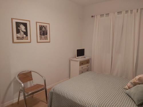 ein Schlafzimmer mit einem Bett, einem Stuhl und einem Schreibtisch in der Unterkunft Casa de la Sierra in Arroyo de la Plata