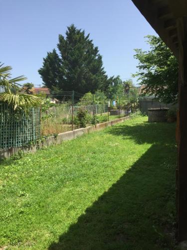 a grassy yard with a fence and trees at REVERIE D'ETE in Vic-Fezensac