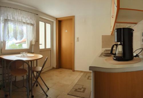 a kitchen with a small table and a counter top at Apartman Dabecic in Dobra Voda