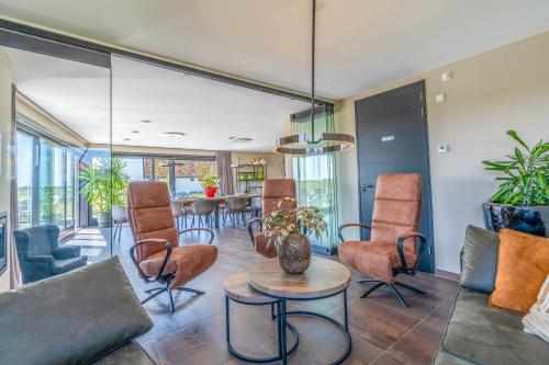 a living room with a couch and chairs and a table at Natuurvilla 18 Waswaal in De Waal