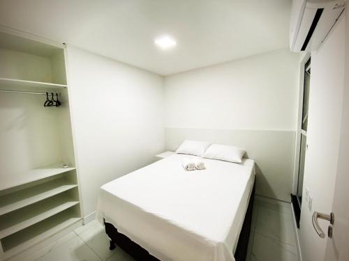 a small white room with a bed and a closet at Aquarius Residence in Fortaleza