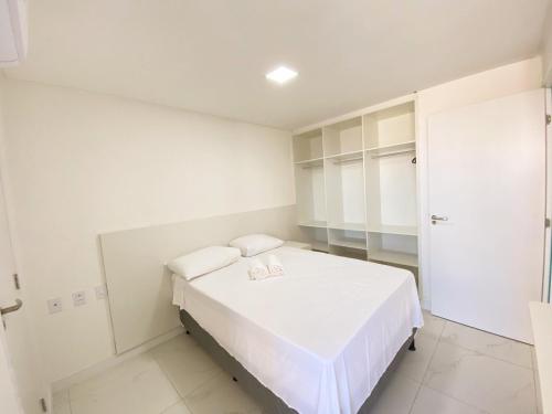 a white room with a bed and a closet at Aquarius Residence in Fortaleza