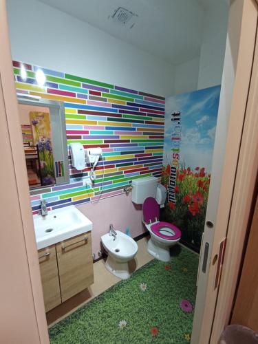 a bathroom with a rainbow mural on the wall at Milano Ostello in Milan