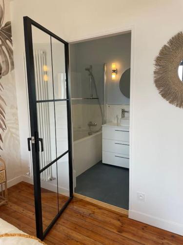 une salle de bain avec une douche, un lavabo et un miroir dans l'établissement Belle maison de campagne d'architecte, pétanque et rando, plages à 5 min !, à Plestin-les-Grèves