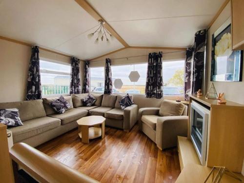 sala de estar con sofá y TV en Cosy & Beautiful Charrot Caravan, en Steeple