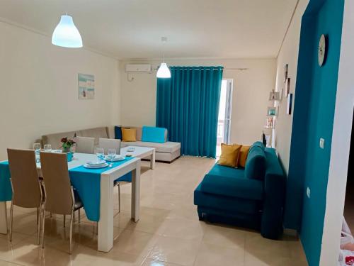 sala de estar con mesa y sofá azul en AQUATIC Apartments Sarande, en Sarandë