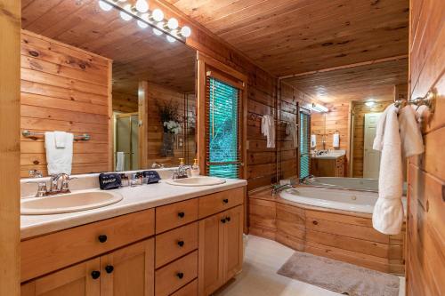 ein Holzbadezimmer mit 2 Waschbecken und einer Badewanne in der Unterkunft Trillium in Banner Elk