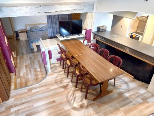 a dining room with a wooden table and chairs at Maison accueillante avec jardin proche d'Échenans. in Échenans
