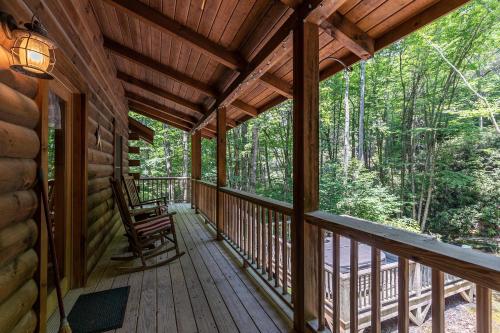a porch of a cabin with a chair on it at Yearling in Banner Elk