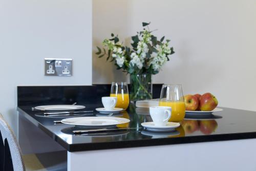 a table with plates and glasses of orange juice at Cheval Harrington Court at South Kensington in London