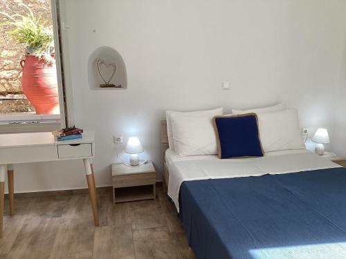 a bedroom with a bed and a desk and a window at Landro House in Kissamos