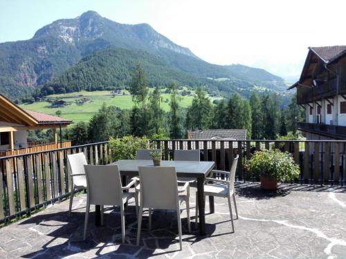 una mesa y sillas en un patio con una montaña en Zimmer 3 am Manötscherhof en Tires