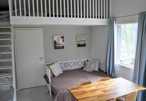 a small bedroom with a bunk bed and a table at Cozy 4 person guesthouse on quiet residential area in Oulu