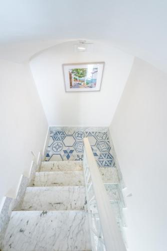 a staircase in a white room with tile floors at Le Volte Procida Home in Procida
