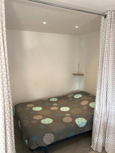 - une chambre avec un lit et des rideaux dans l'établissement Superbe appartement au calme et vue sur la mer, à Cagnes-sur-Mer