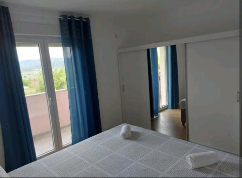 ein Schlafzimmer mit einem Bett und einem großen Fenster in der Unterkunft APARTMAN HOPE in Zmijavci