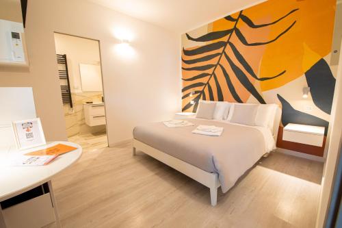 una camera da letto con un letto e un dipinto sul muro di Resilienza Tropical Apartments & Room a Porto SantʼElpidio