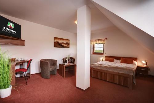 Habitación de hotel con cama, escritorio y silla en Golf&Wellness Resort Alfrédov en Alfrédov