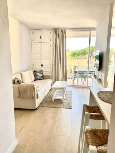 sala de estar con sofá blanco y mesa en Precioso estudio a 300m de la playa, en Platja d'Aro