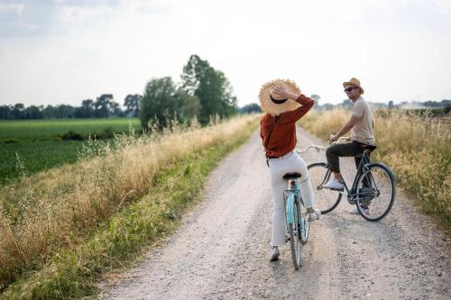 a man and a woman riding bikes down a dirt road at Hotel Airone in Piadena