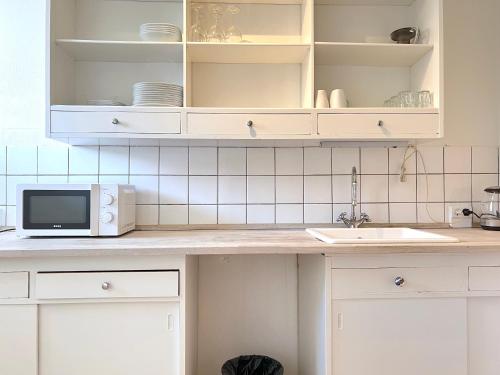 a kitchen counter with a sink and a microwave at Studio Apartment In Glostrup Near Shopping Areas in Glostrup