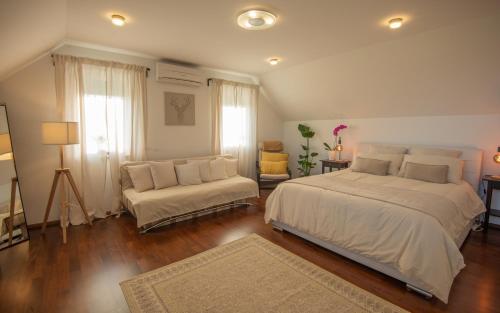 1 dormitorio con 1 cama grande y 1 sofá en Vineyard cottage Jelenov hrib en Smarjeske Toplice