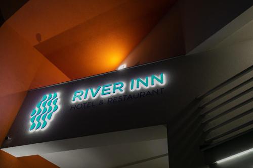 a sign for a hotel and restaurant on a wall at River Inn in Stari Banovci