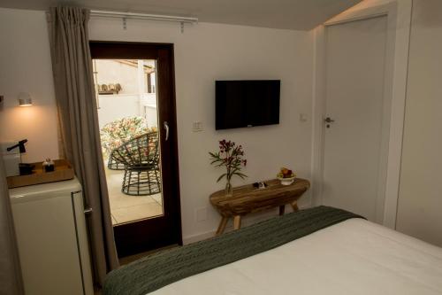 a bedroom with a bed and a television and a table at Hostal del vino LA COSTERA in Altea