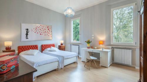een slaapkamer met 2 bedden, een bureau en 2 ramen bij VILLA RUSTICA 8, Emma Villas in San Pietro in Vincoli