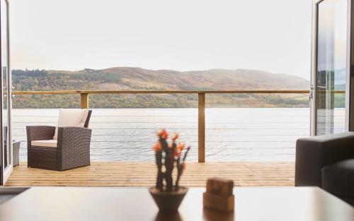 a living room with a view of the water at Shoreland Lodges - Holly Lodge in Fort Augustus