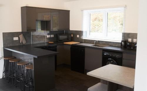 a kitchen with a black counter and a sink at Shoreland Lodges - Holly Lodge in Fort Augustus
