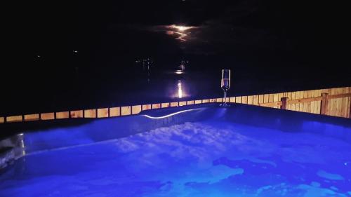 a swimming pool at night with a light in the background at Shoreland Lodges - Holly Lodge in Fort Augustus