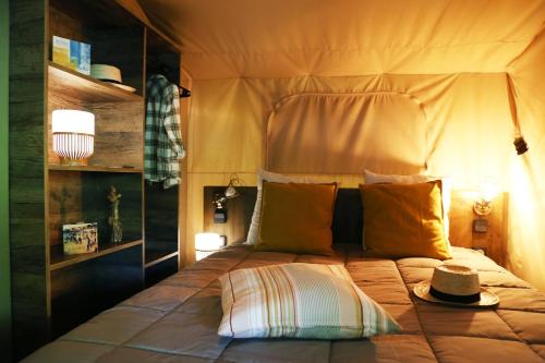 un lit avec un chapeau installé au-dessus dans l'établissement Camping Moulin de Paulhiac, à Daglan
