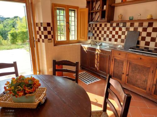 a kitchen with a wooden table with a vase on it at Dependance nel Chianti a pochi minuti da Firenze in Impruneta
