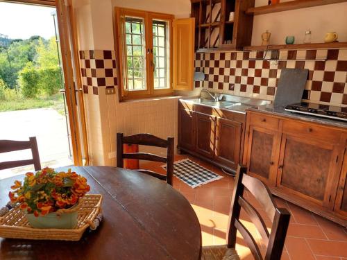 una cucina con tavolo in legno e vaso; di Dependance nel Chianti a pochi minuti da Firenze a Impruneta
