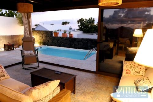 a living room with a view of a swimming pool at VILLAZUL by Villitas in Playa Blanca