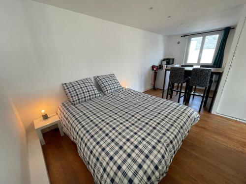 une chambre avec un lit, une table et des chaises dans l'établissement Les 4 saisons Honfleur - Studio 3, à Honfleur