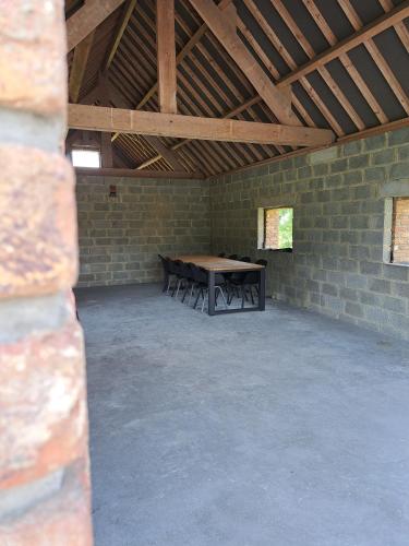 a room with a wooden table in a brick wall at Gîte L'Olivier à Filly - Nadrin, entre Houffalize et La Roche-en-Ardenne in Houffalize
