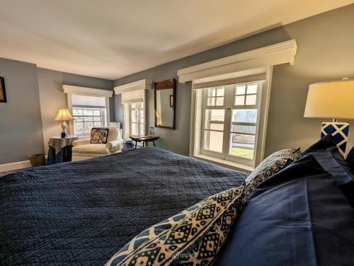a bedroom with a bed and a chair and a window at Cromwell Manor Inn in Cornwall-on-Hudson