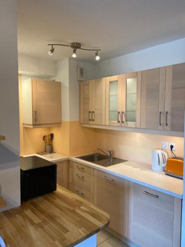 une cuisine avec des armoires en bois et un évier dans l'établissement Chez Louis de Uzès, à Uzès