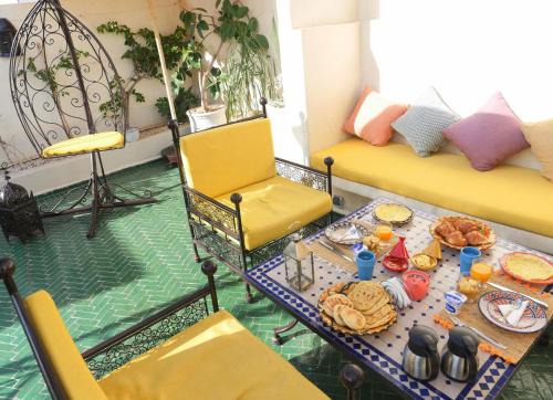 una sala de estar con una mesa con comida. en SARDINAS & CHILI, en Marrakech