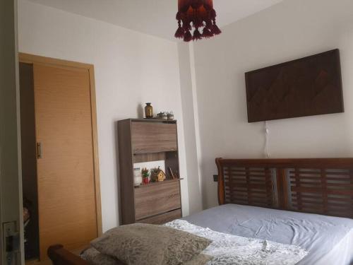 una camera da letto con un letto e una televisione a parete di Your Sweet Appartment a Fes
