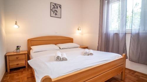 ein Schlafzimmer mit einem Bett mit weißen Schuhen darauf in der Unterkunft Calma apartments in Trogir